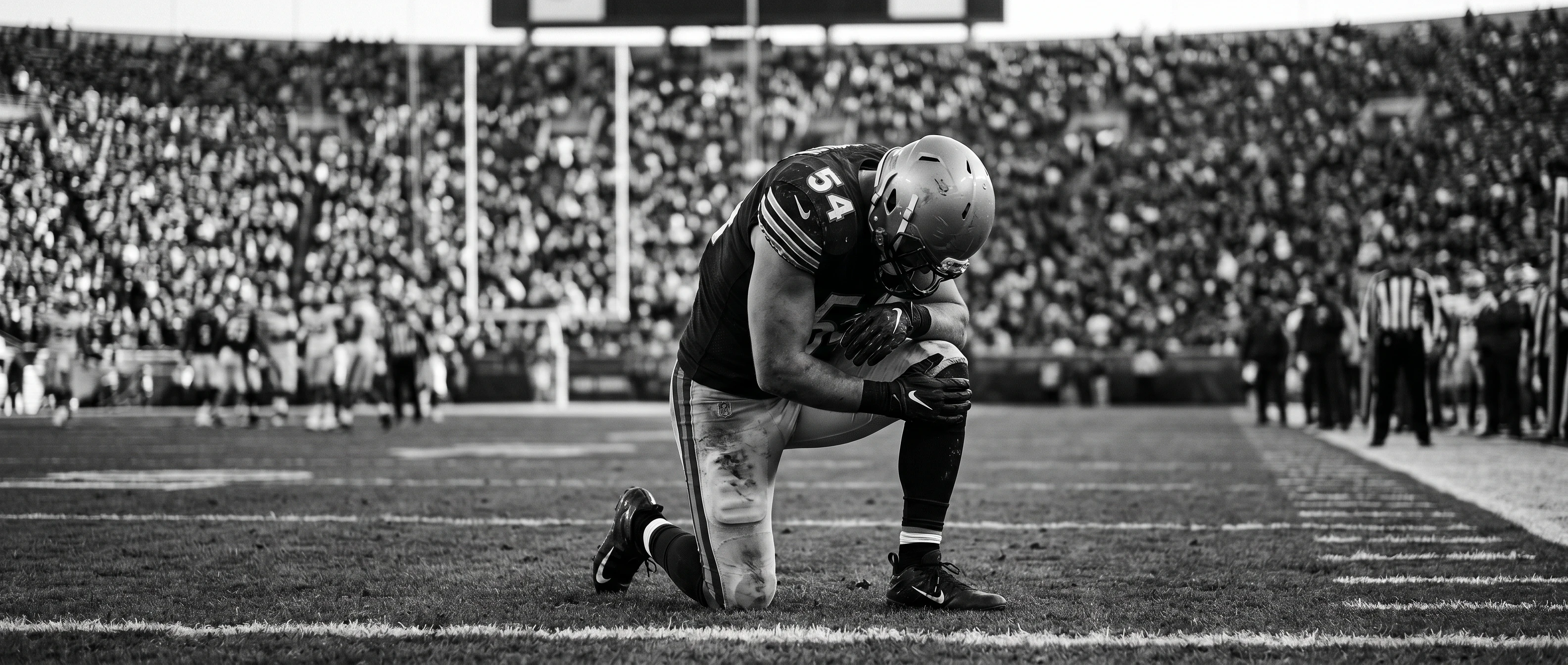 Injured football player holding his knee on the field