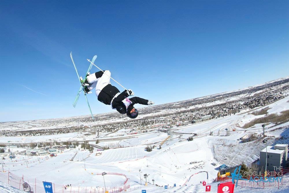 Spencer Belsky inverted in an aerial above a ski park